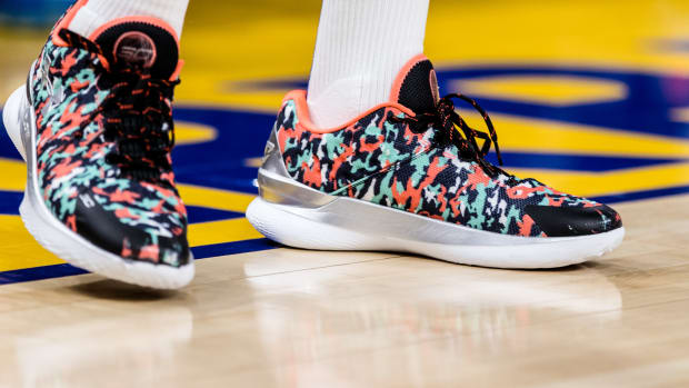 View of black, green, and orange Curry shoes.